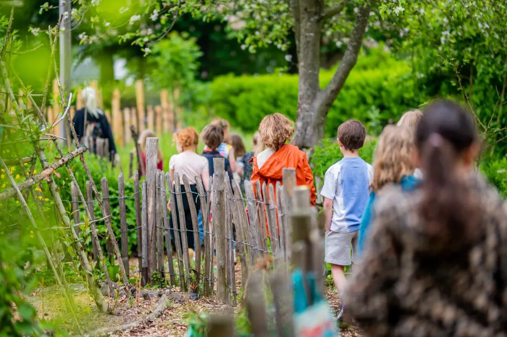 kinderen lopen langs een hek